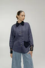 Camisa azul de lino con cuello, bolsillo y puños de crochet negro, con botones de madera.