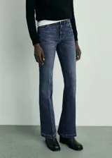Pantalón de jean azul oscuro, tiro bajo, corte flare y cinco bolsillos.