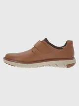 Zapato marrón de cuero con ajuste de velcro y suela gruesa color crema.