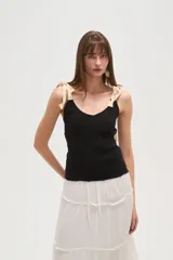 Musculosa negra con breteles finos, escote en V, punto smock y lazos en los hombros.