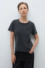 Remera de algodón color bordó, con cuello redondo, manga corta y detalle de ojalillos metálicos en el borde de las mangas.