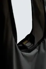 Bolso shopper gris confeccionado en tejido técnico con cierre mediante hebilla de liberación rápida, asa de hombro y logo estampado. Plegable tamaño bolsillo.