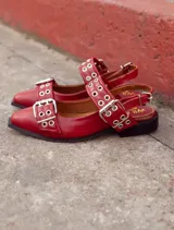 Ballerinas rojas de cuero con suela de madera y goma. Tiene detalle de tiras con ojalillos y hebillas metálicas. El interior está forrado con forreria vacuna al igual que la plantilla.