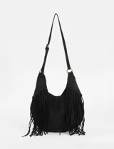 Cartera bandolera de estilo boho con flecos largos en los laterales. Cuenta con una correa ajustable con hebilla y herrajes metálicos en tono bronce.