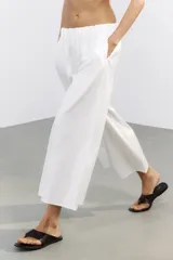 Pantalón culotte negro de tiro medio con cintura elástica y bolsillos laterales ocultos en la costura.
