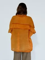 Camisa color amarillo con cuello clásico, cierre frontal con botones y mangas cortas con volados.