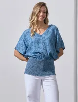 Blusa celeste con estampado floral, escote en V y ruedo smock.