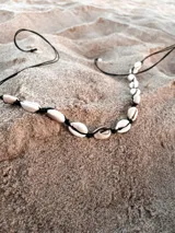 Collar de hilo negro con conchas marinas blancas.