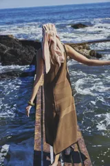 Vestido midi color crema, tejido de punto con bloques de diferentes texturas, escote redondo y sisas con terminación ondulada.