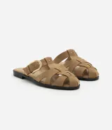 Sandalia plana color beige, tipo mule fisherman, con tiras trenzadas, hebilla lateral y suela negra.
