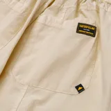 Pantalón cargo color crema, de corte ancho, con bolsillos laterales y costuras a la vista.