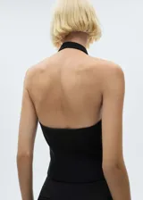 Chaleco negro con cuello halter, espalda descubierta y cierre frontal con botones.