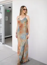 Vestido largo con tirantes finos y estampado tipo acuarela en tonos tierra y celeste.