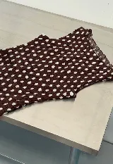 Top sin mangas con cuello redondo y diseño ajustado con frunces elásticos a cuadros rojos y blancos.