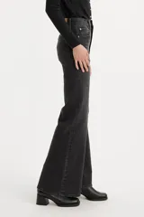 Pantalón de jean negro de tiro alto, corte acampanado y bajo desflecado.