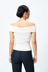 Top tejido color blanco con escote bardot que deja los hombros al descubierto y punto acanalado.