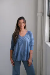 Remera celeste con cuello en V, manga larga y estampado con diseño de rombos en el frente.