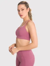 Top deportivo negro con tirantes dobles en la parte delantera y almohadillas removibles.