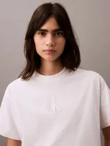 Remera blanca de algodón con cuello redondo y logo CK bordado en el pecho. Corte cropped y mangas cortas.