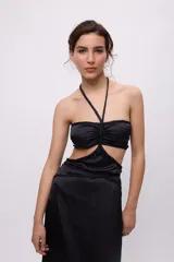 Vestido midi amarillo de satén con escote halter, trenzas en cuello y cintura, cut-outs laterales y falda recta.