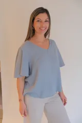 Blusa celeste de tela tipo jean, con escote en V y mangas cortas con volados.