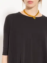 Remera negra de corte holgado con mangas 3/4 y cuello redondo.