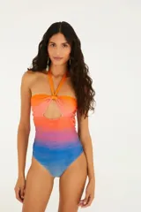 Traje de baño entero con estampado ombré en tonos naranja, rosa y azul. Diseño con escote halter y abertura en el centro del pecho.