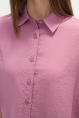 Camisa holgada de viscosa color rosado, con cuello camisero, manga corta y cierre frontal de botones.
