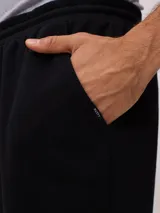 Bermuda deportiva gris confeccionada en 60% algodón y 40% poliéster, con cintura elástica ajustable con cordón.