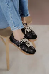 Championes acordonados color beige y dorado con suela marrón.