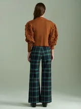 Cardigan marrón de tejido de punto con cierre frontal, cuello redondo y mangas abullonadas con apliques de pompones.