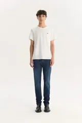 Pantalón de jean azul oscuro, corte slim fit, tiro medio y confección sin elasticidad.