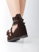 Sandalias de cuero marrón con acabado en gamuza, taco de 8 cm y plataforma forrada. Diseño con doble tira ajustable con hebillas metálicas y cierre trasero.