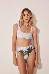Conjunto de bikini con corpiño de tirantes con estampado a rayas verticales en blanco y celeste, y bombacha de tiro alto con estampado de palmeras y cielo celeste.