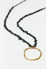 Collar largo con cadena dorada, cuentas de piedras naturales grises y dije circular irregular de acero dorado.
