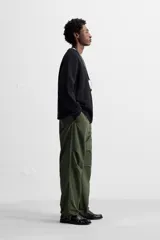 Pantalón verde militar de corte relaxed fit confeccionado en tejido técnico ligero. Cuenta con cintura elástica ajustable con cordón interior, bolsillos frontales y traseros con solapa, pliegues en las rodillas y bajo ajustable con elástico.