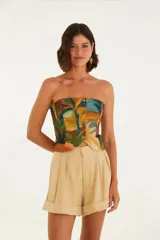 Short de vestir color beige, con cintura alta, pliegues frontales, bolsillos laterales y ruedo con dobladillo.