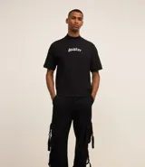 Pantalón cargo recto color negro, de sarga de algodón, con bolsillos laterales con hebillas y trabillas en la cintura.