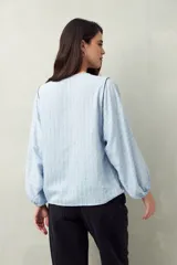 Camisa blanca a rayas grises, de lino, con cuello mao, mangas largas abullonadas y bordados en las sisas.