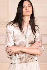 Bomber de seda con estampado batik, cuello redondo, cierre frontal con cremallera, mangas cortas y puños elásticos.