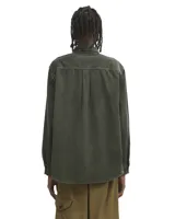 Camisa de manga larga confeccionada en pana de color azul marino, con cuello clásico y cierre frontal de botones. Presenta un bolsillo de parche en el pecho con la etiqueta de la marca Carhartt.