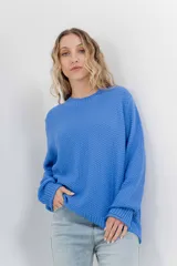 Sweater azul de punto medio, amplio, suave, con escote a la base y puños en mangas y en acabado inferior.