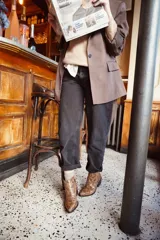 Botas de cuero con estampado de piel de serpiente en tonos burdeos y marrón con brillo dorado. Diseño de punta alargada, altura hasta el tobillo, cierre lateral y mini taco de 2.5cm.