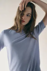 Top celeste de punto fino con cuello redondo y mangas cortas.
