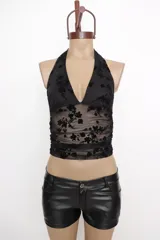 Top negro con estampado floral, escote halter y espalda descubierta.
