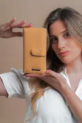 Billetera larga color camel con presilla y broche a presión. Interior con visor, tarjeteros y bolsillos. Compartimento posterior con cierre metálico, incluye bolsillos y monedero con cierre.