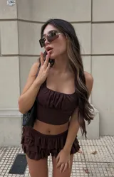 Conjunto de top y minifalda marrón chocolate con volados. El top es corto, con escote cuadrado y fruncido. La falda es corta con volados.