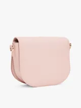 Cartera saddle Tommy Hilfiger color rosa con correa de textil trenzado con inscripciones de la marca y logo TH brillante en el frente.
