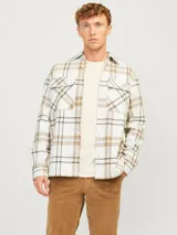Sobrecamisa a cuadros color blanco, marrón y negro, de manga larga con cierre de botones y bolsillos en el pecho.