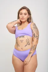 Bombacha de bikini ancha en los costados, de tiro alto y corte cavado. Totalmente forrada, color negro con ribete blanco.